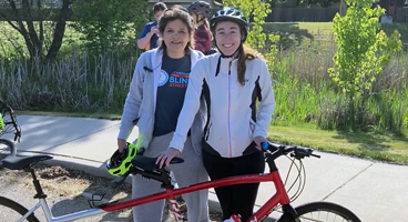 Erin and Laura smile as they prepare for a tandem bike ride together.