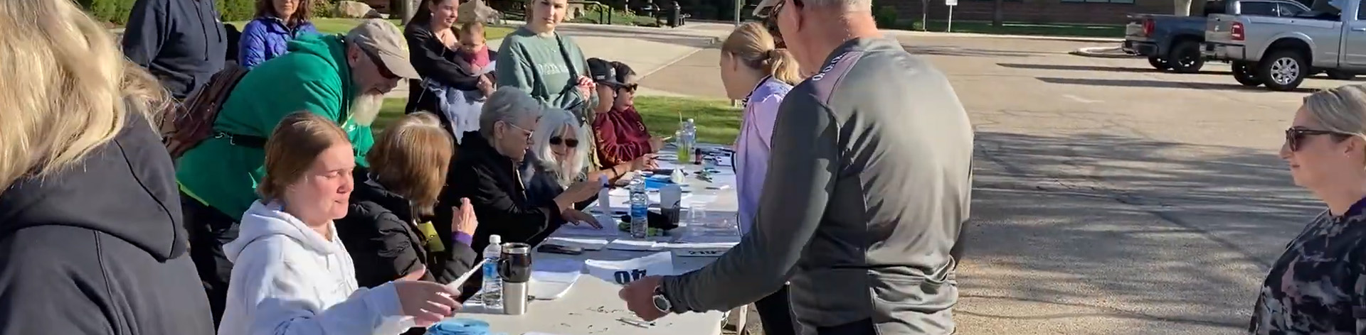 A table full of NFB volunteers smiles as they sign up cycling race participants.